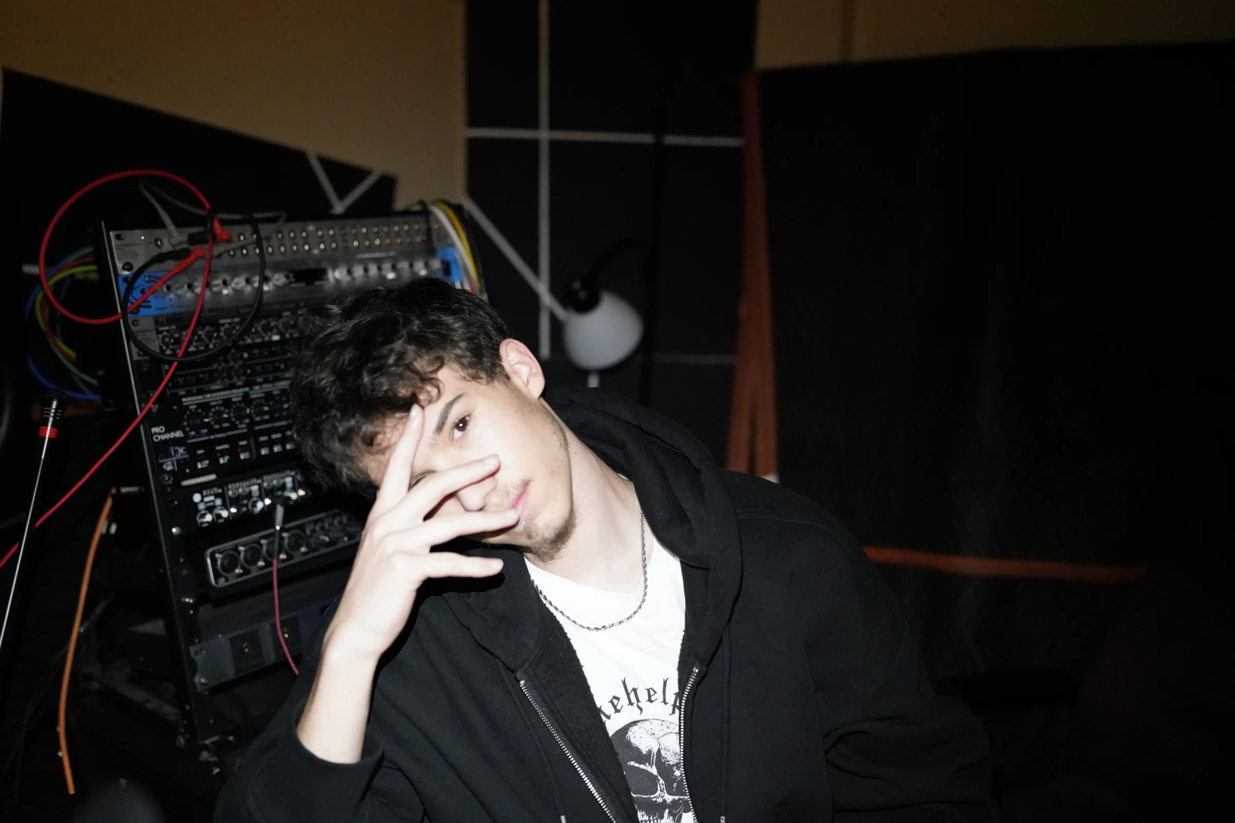 Zardex seated beside the Studio B recording rack at Checkmark Audio