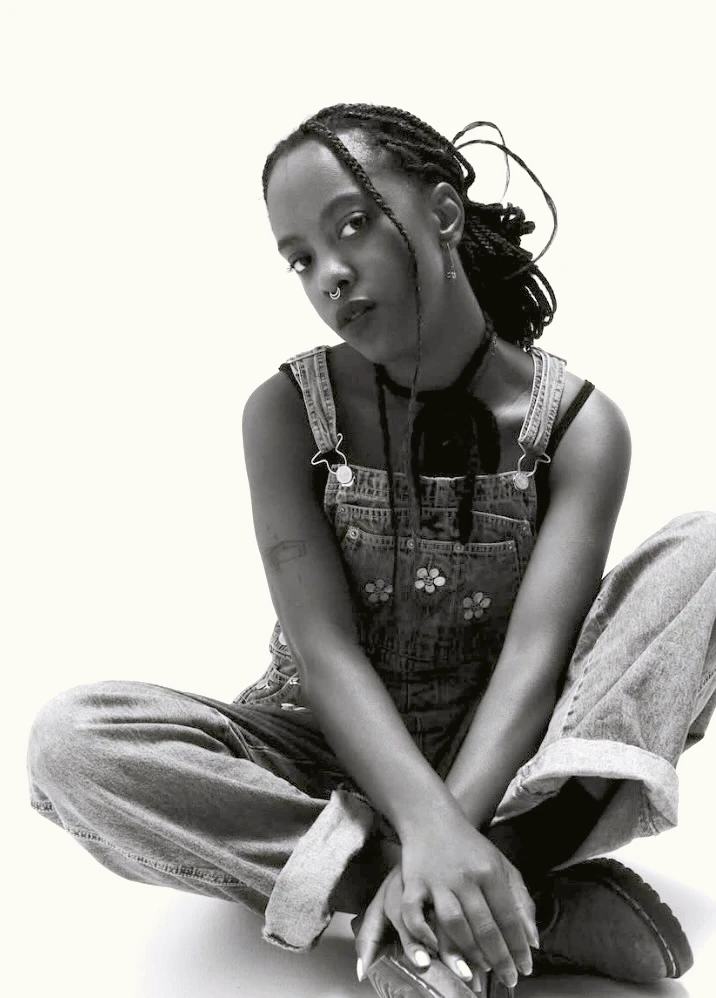 Kai Warrior seated in a black-and-white artist portrait
